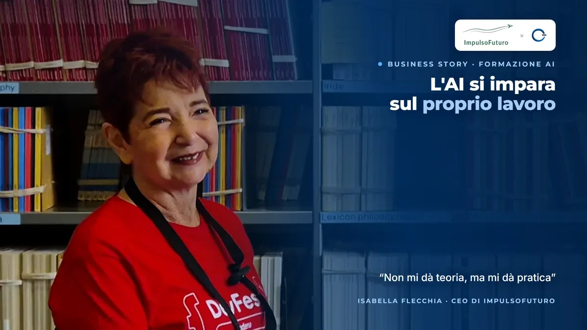 Isabella Flecchia, CEO of ImpulsoFuturo, smiling in a red DevFest Modena T-shirt in front of library shelves, during the video testimonial